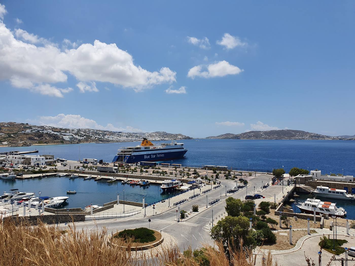 A Blue Star Ferries ship docked at the new port at Tourlos on Mykonos, with the marina and town beyond