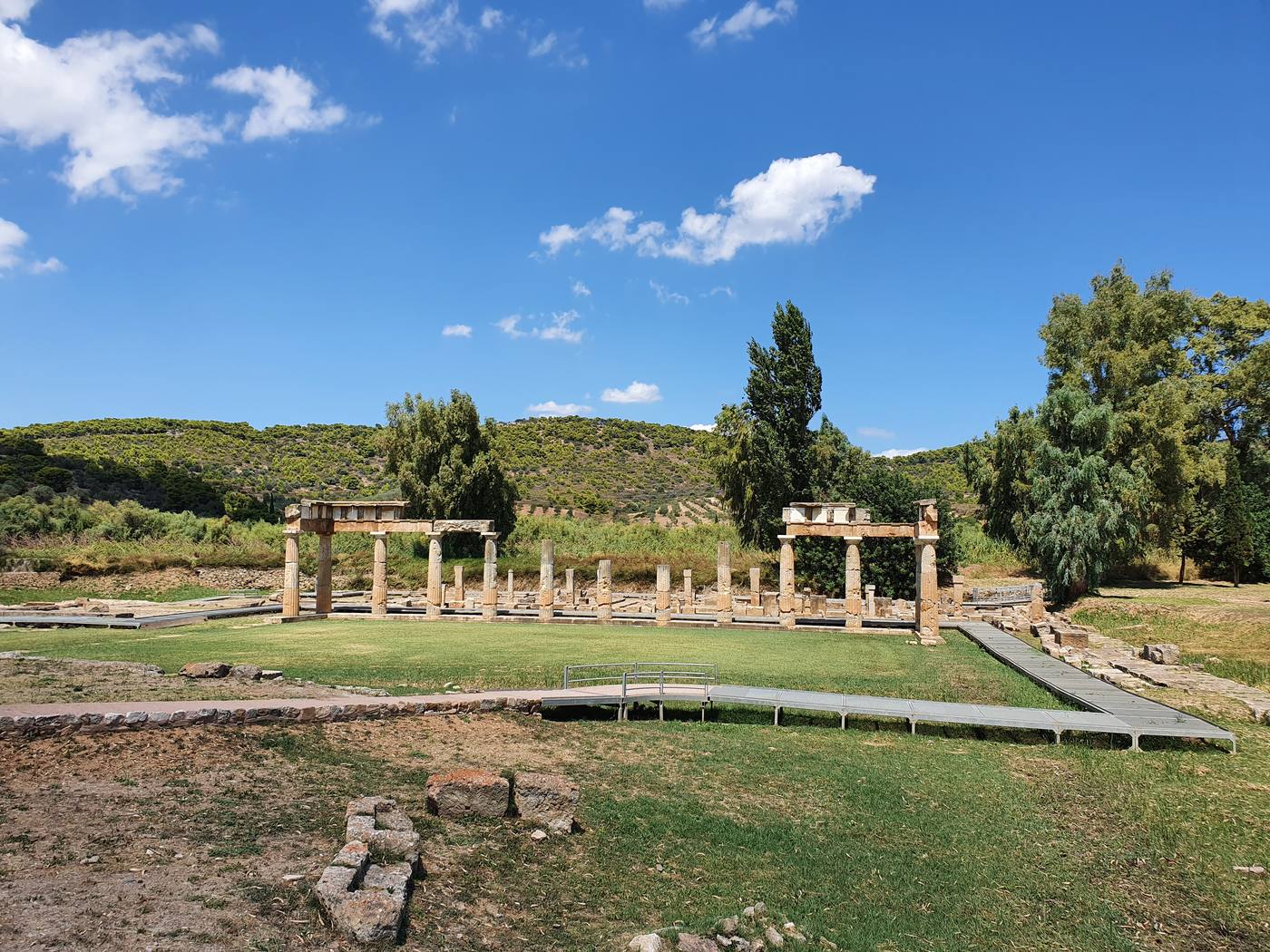 The restored stoa colonnade of the Sanctuary of Artemis at Brauron, standing in a green marshy valley