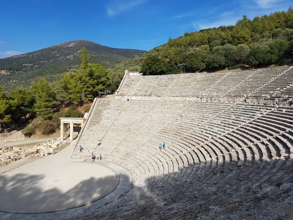 The stone tiers of the ancient theatre of Epidaurus fanning out below the surrounding hills
