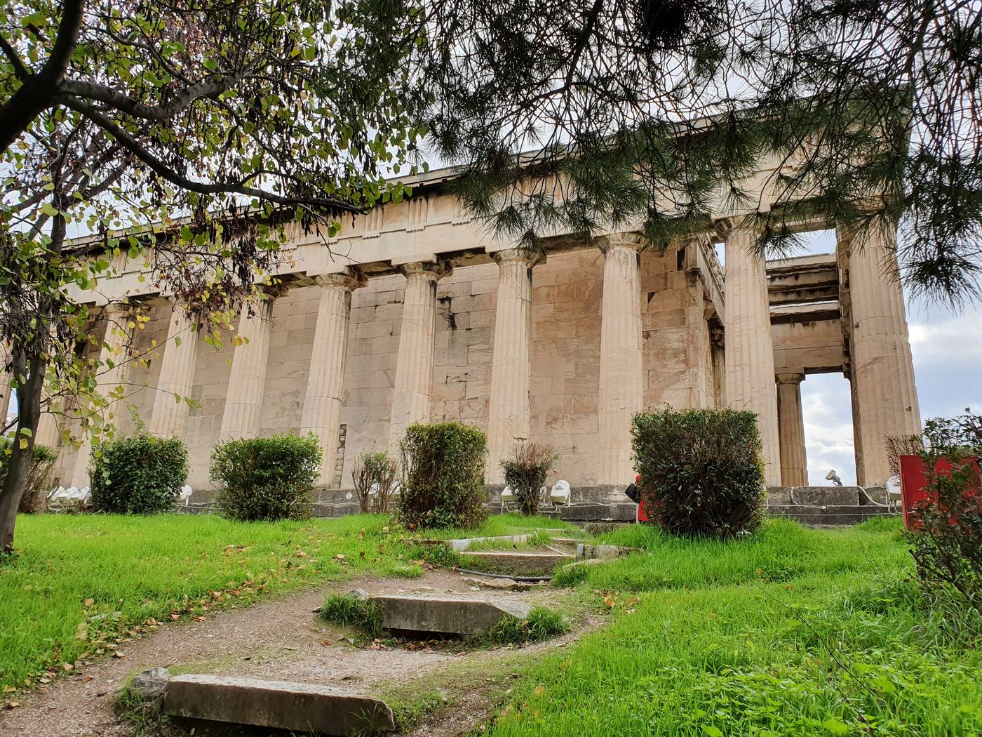The well preserved Temple of Hephaestus among trees in the Ancient Agora of Athens