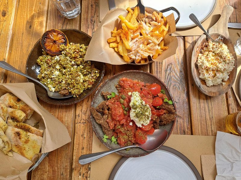 A table spread with traditional Greek meze dishes including salads, cheese spreads, and bread