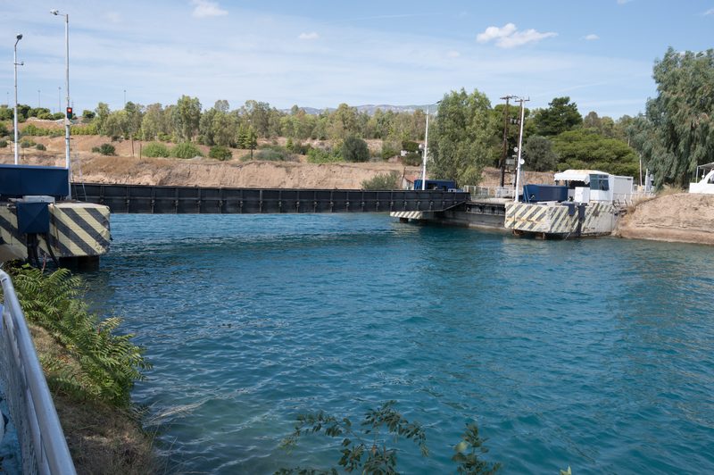 The Isthmia submersible bridge spanning the Corinth Canal at its eastern entrance, with the narrow canal walls visible on both sides