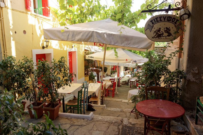 Daytime view of restaurants lining Mnisikleous Street in the Plaka neighborhood of Athens