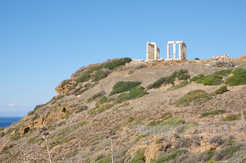 Temple of Poseidon ruins at Cape Sounion with ancient columns against a blue sky and sea